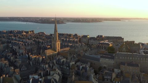 France, Bretagne, Brittany, Saint-Malo, drone aerial view above old city center and Saint-Vincent church at sunset (or sunrise)
