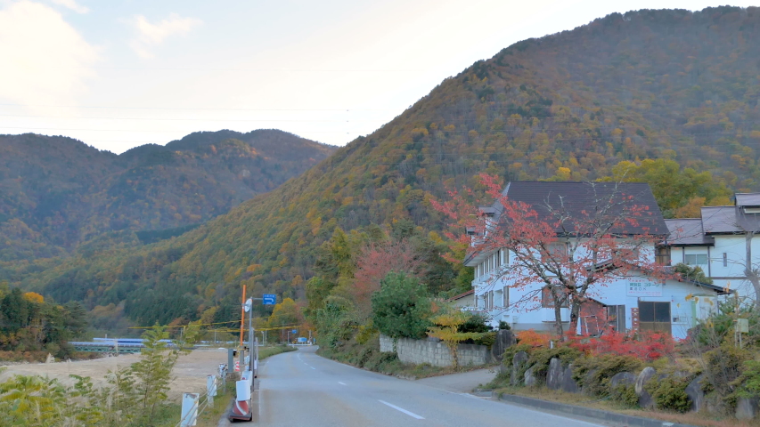 The houses on the side of the small road in Kurobe Japan in between the river and the mountains