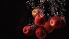 Red apples with water droplets collide on black background. Fruits falling into water. Red prince apple. Slow motion 4k - Powered by Shutterstock - Get 15% off with code: PIKWIZARD15