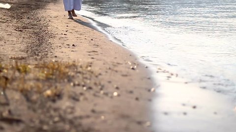 Jesus walking towards us, on the seashore, medium shot