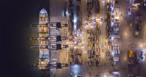 Aerial hyperlapse bird�s eye view of trucks and cranes moving containers at night in Santos port. Sao Paulo, Brazil