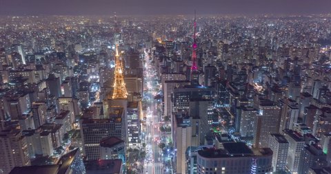 Aerial hyperlapse of huge city at night with buildings, antenas and cars driving.Wide shot of Paulista avenue and Sao Paulo. Brazil