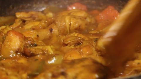 Simmering chicken with vegetables in a metal skillet
