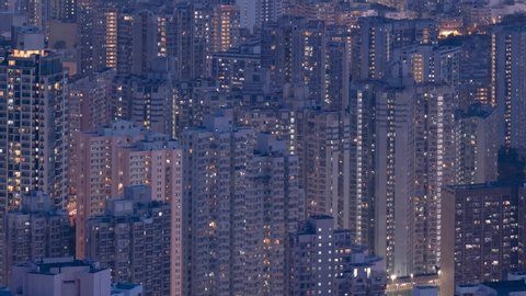 Crowded city with lights turning on and off at night. Hong Kong city apartment buildings at night. 