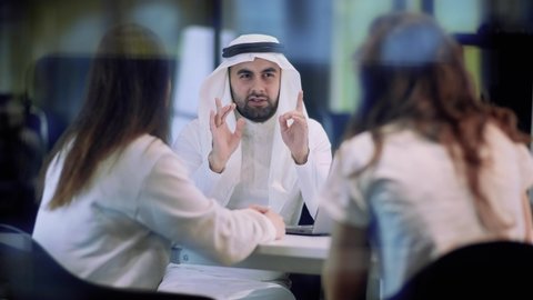 Arab businessman in a meeting with business partners leads a conversation.