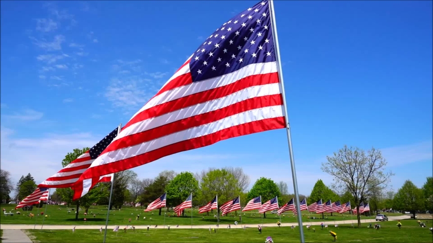 American flags placed up in the Milwaukee, Wisconsin community to honor veterans memorial day slowly waving in the wind. 1080p, 720p