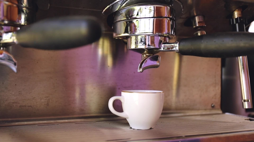 Coffee pouring into the cup in the professional coffee machine. Coffee shop or restaurant setting. Professional food and beverage establishmenr, eatery concept | Shutterstock HD Video #1053160046