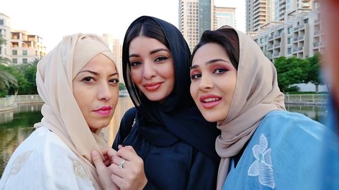 Three friends making shopping and spending time together in Dubai. Group of women wearing traditional uae abaya clothes outdoor