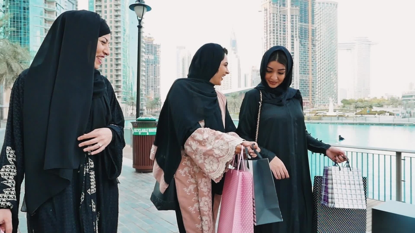 Three friends making shopping and spending time together in Dubai. Group of women wearing traditional uae abaya clothes outdoor Royalty-Free Stock Footage #1053161543