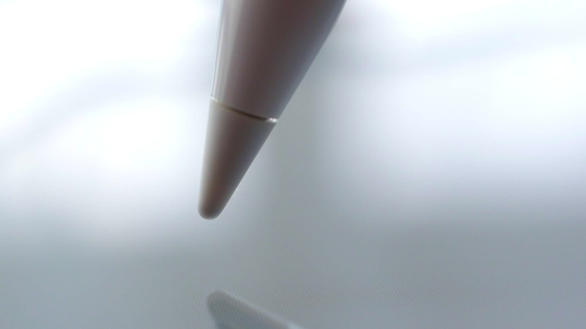 Macro Follow Shot of an artist hand drawing on a digital tablet with pencil. Pencil is Connected to the Camera. Gripped Shot. Royalty-Free Stock Footage #1053162671