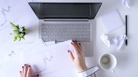 Time lapse. Working office day. Woman worker cleaning laptop using antivirus wet wipe. type keyboard, cup of coffee, graphics and charts printed on the paper. Flat lay  - Powered by Shutterstock - Get 15% off with code: PIKWIZARD15