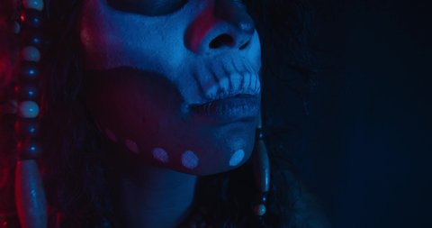 Portrait of a tribal shaman in red and blue lighting, looking around, 4k