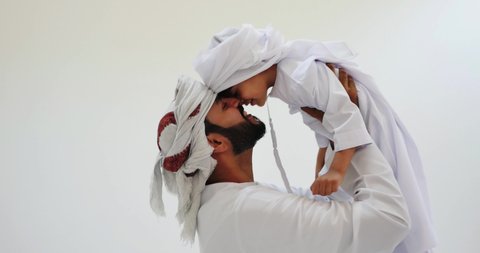 Happy father and son playing together, People from UAE wearing traditional outfits