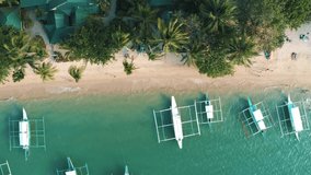 Top drone view of a traditional philippine boats on the surface of the azure water in the lagoon. Seascape with blue bay and boats. El Nido, Port Barton, Palawan. Summer and travel vacation concept.