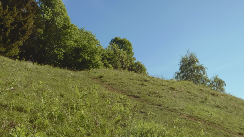 A MTB E-biker biking down the hill in the nature. Extreme rider is making jump trick.