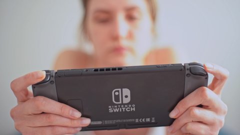 New York City, New York, USA - May, 15 2020, game console Nintendo Switch in the hands of a young woman close-up