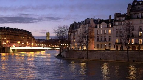 Cityscape of Paris, France. View on the Seine river and on the "île de la cité" and the "île saint louis". Filmed at night just after the sunset.