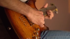 A young man plays the electric guitar at home. Golden amber sunburst guitar. Close-up. - Powered by Shutterstock - Get 15% off with code: PIKWIZARD15
