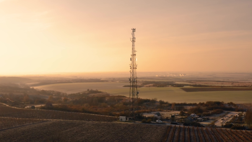 Communication transmitter tower in the countryside aerial view drone footage. Cellphone network antennas amitting radio waves of many frequencies Royalty-Free Stock Footage #1053171527
