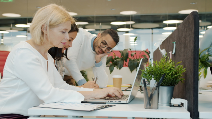 Slow motion of diverse group of people female and male coworkers busy in open space office working talking using modern devices. People and coworking concept. | Shutterstock HD Video #1053173894