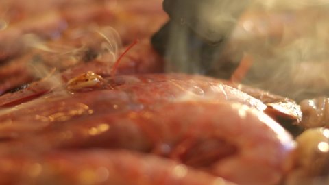 Detail shot of how the prawns are turned while preparing a paella