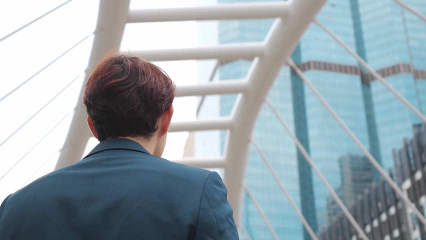 360 Degree Tracking Shot of the Thoughtful Businessman mixed wearing a Suit looking out while standing near modern Office Building. 4K Slow Motion Corporate Shot with Moving Around 360 Camera. | Shutterstock HD Video #1053175355