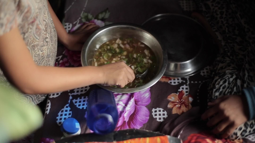 Brown Nepali Indian children play in the room and prepare food from water and greenery. Close-up
