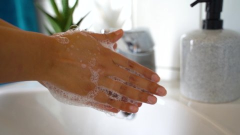 Coronavirus pandemic prevention wash hands with soap warm water rubbing fingers washing frequently or using hand sanitizer gel.