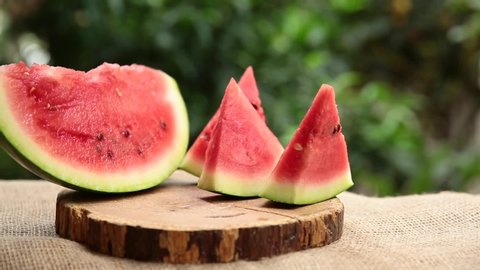 The most important fruit of the summer season is watermelon. camera movements. Sliced ​​watermelon in front of the leaves. watermelon rind.