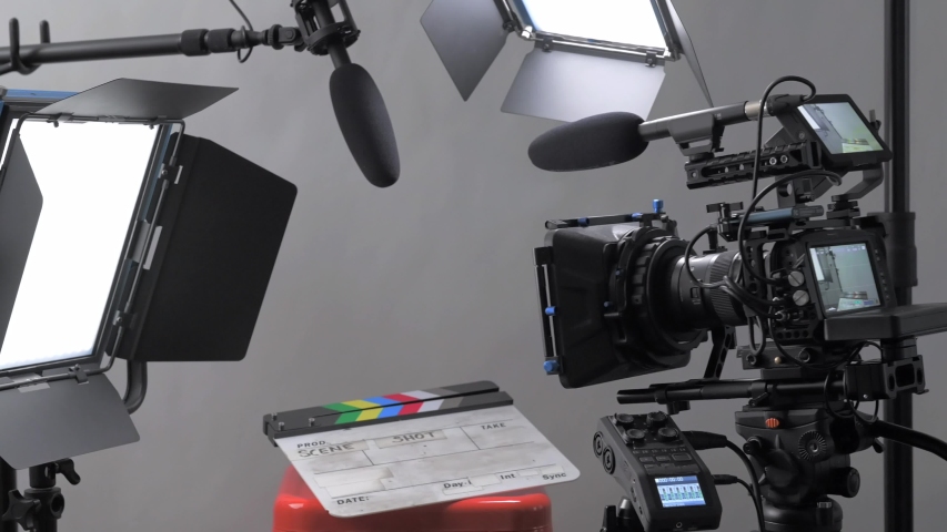 Slider dolly panning shot moving through a professional video production film set with camera, lights, and microphone all set up for an interview in a studio setting.  | Shutterstock HD Video #1053196613