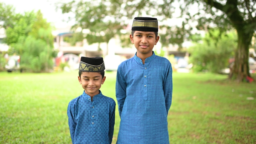 Asian muslim boy wearing traditional costume and looking at camera to  celebrate festival of eid mubarak. hari raya aidilfitri festival. eid  mubarak celebration in malaysia, brunei and indonesia.