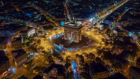 night time illumination paris city center triumph arch traffic circle street aerial timelapse panorama 4k france