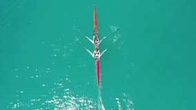 Aerial drone video of women paddling in sport canoe in tropical exotic emerald calm water lake