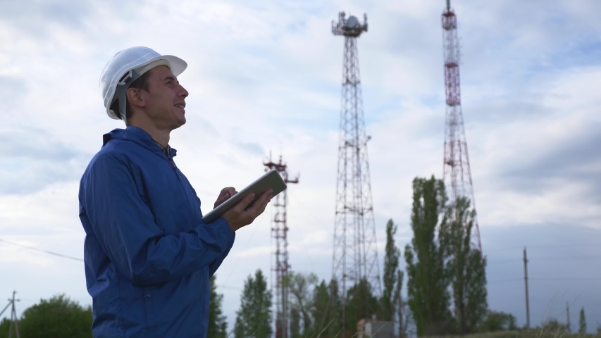 A telecommunications engineer working on a digital tablet records data for maintenance of the telecommunications network. Design, repair and installation of satellite and telecommunications networks. Royalty-Free Stock Footage #1053207800