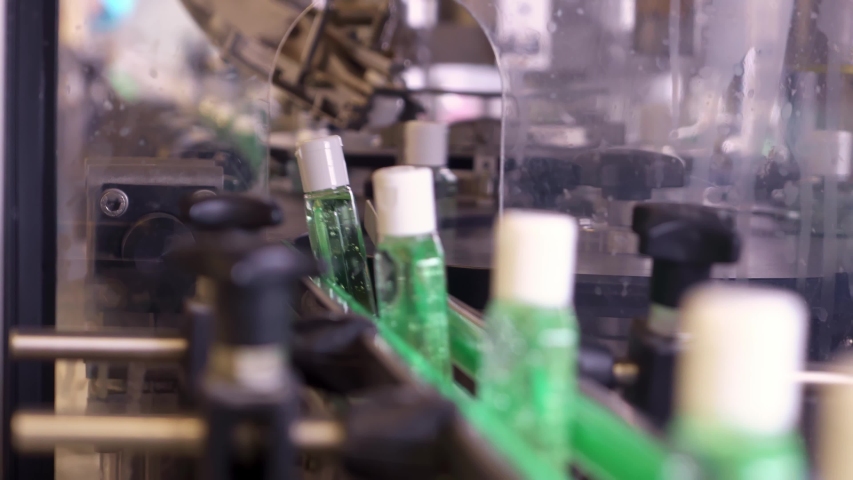 Plastic bottles for sanitizers gel are moving along the conveyor belt at the factory for the production of personal protective equipment. Royalty-Free Stock Footage #1053210854