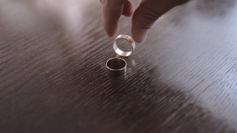 Spinning wedding rings, slow motion of rotating rings, close up dolly shot of turning wedding rings. Morning of the groom