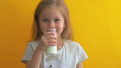 Happy girl hold glass of milk yellow background. Enjoying natural cows milk. Diet and nutrition. Healthy dieting. Good habit. Dairy products. Drink more milk