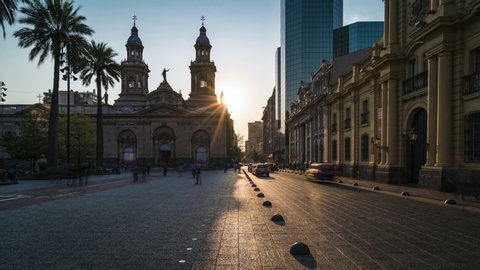 Timelapse view of sun setting behind historical landmark Santiago Metropolitan Cathedral at Plaza de Armas square in downtown Santiago, the capital and largest city in Chile, South America. 