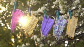 A reusable DIY fabric cotton mask is dried on a clothesline in the open air for reuse. Covid-19 Pandemic. Cloth Face Mask Washing, Drying, Cleaning, Disinfection and Sterilization - Powered by Shutterstock - Get 15% off with code: PIKWIZARD15