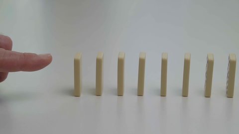 Row of dominoes falling in slow motion