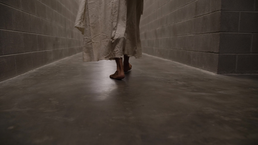 Dramatic, slow motion of Jesus feet walking through prison hallways. Royalty-Free Stock Footage #1053224366