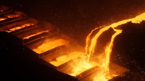 The scene of the smelting molten iron sparks in the blast furnace cast iron machine of the steel plant. High-temperature molten metal sparks everywhere.