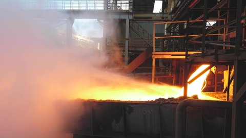 In the iron and steel smelting factory, the fiery red high-temperature slag liquid spews out of the electric furnace and flows into the slag pool, which rises a large piece of high-temperature water