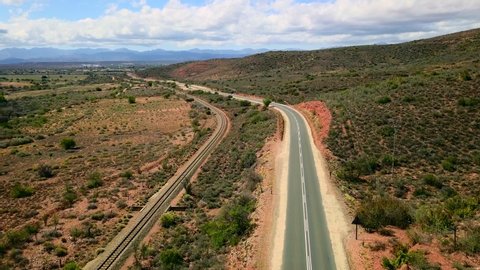 Road and train tracks through arid South African countryside. Aerial