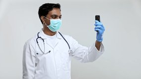 Doctor Having Video Call on Phone Wearing Medical Mask and Gloves Isolated. Indian Man Doctor Video Call. Medicine Online. Doctor Using Phone.