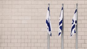State Flag of Israel. The three Big Flags flutter epically in the wind against the bricks wall. National simbol Jerusalem