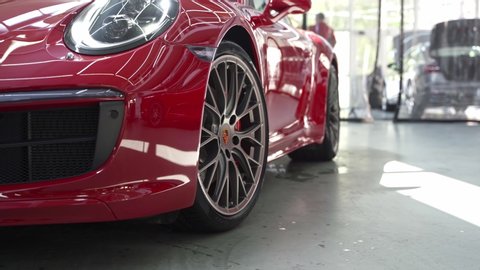 ROSTOV-ON-DON, RUSSIA - APRIL 26, 2020: b roll close up shot of Porsche wheel with big red brake caliper. Porsche 911 Carrera 4S Coupe sports car. 