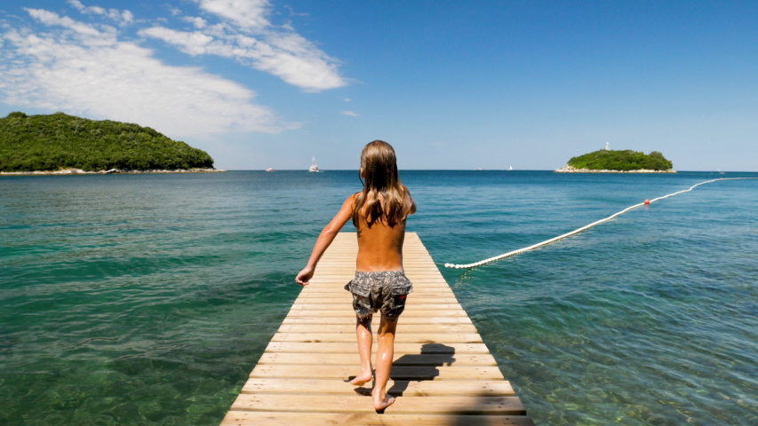 children running and jumping in the blue sea