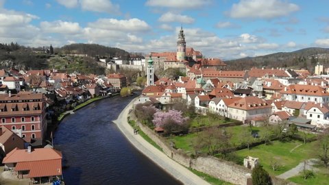 Flight of the drone over the famous ancient czech town Cesky Krumlov. View of the river, red tiled roofs and the castle tower. Czech Republic