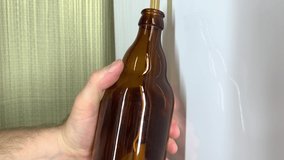 Craft beer brewery. Close up of male's hand filling brown glass beer bottles at home. Self made beer 4k stock video.